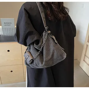Detail of grey denim tote bag with silver chain and matching hanging coin purse