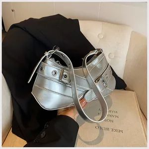 Close-up of metallic silver underarm bag featuring metal eyelets and adjustable strap