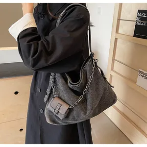 Detail of dark grey tote bag featuring chunky silver chain and matching small pouch
