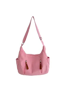 Pink corduroy crossbody bag with adjustable wide strap and brown leather zipper pulls