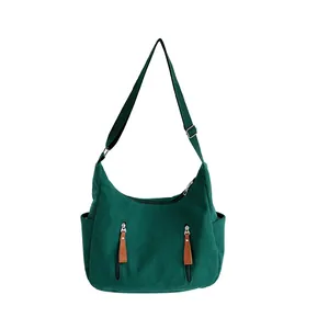 Dark green corduroy dumpling bag with adjustable strap and multiple zipper pockets
