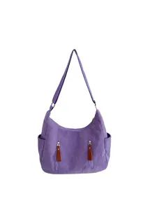 Detailed view of purple corduroy dumpling bag with dual vertical zipper pockets and side slots