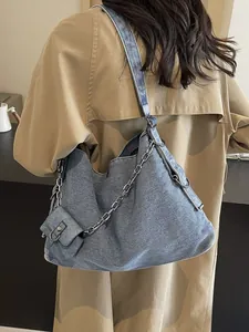 Large capacity blue denim hobo bag with silver chain strap and mini pouch on shoulder