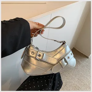 Close-up of metallic silver crescent bag featuring dual buckles and eyelet metal accents