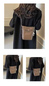 Detail view of a brown leather bucket bag with decorative buckle and chain brand tag