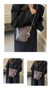 Detail of dark brown leather bucket bag featuring silver chain and brand tag decoration