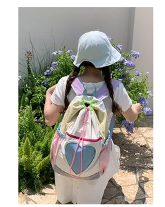 Dettaglio di uno zaino multicolore con coulisse e tasca a rete blu a forma di cuore