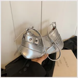 Detail showing metallic silver hobo bag with punk-style eyelets and buckle strap