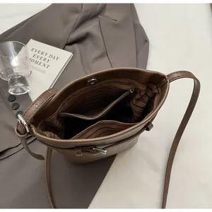 Detail of dark brown leather bucket bag showing striped lining and magnetic closure