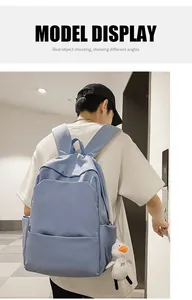 Rear view of light blue waterproof backpack with cute plush duck pendant accessory