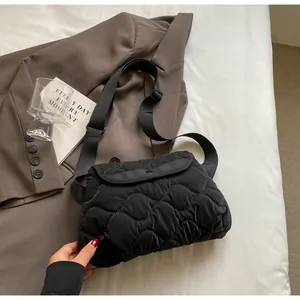 Detailed wave quilting texture and adjustable wide strap on black quilted crossbody bag