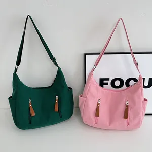 Corduroy hobo bag in pink and dark green with front zippers and adjustable straps