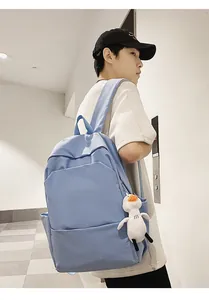 Detail of light blue waterproof backpack with side pockets and cute duck charm