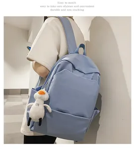 Light blue waterproof backpack with cute white duck plush keychain and side view details