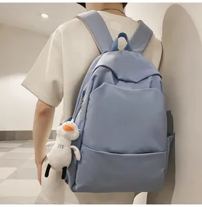 Rear view of a light blue waterproof backpack with a cute white duck plush charm