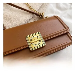 Macro shot of retro brown oil wax leather bag with elegant gold geometric metal buckle