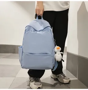 Detail of light blue waterproof backpack with cute plush duck pendant for students