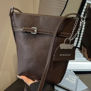 Dark brown leather bucket bag with silver chain charm and adjustable shoulder strap