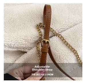 Close-up of brown leather adjustable shoulder strap with gold buckle and chain