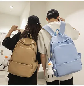 Detail view of khaki and light blue waterproof backpacks with cute duck plush pendants