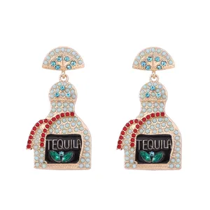 Detail of gold tequila bottle earrings with rhinestone beads and lime slice design