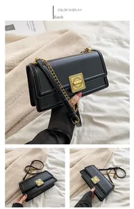 Detail view of black PU leather shoulder bag with vintage gold square buckle and chain strap