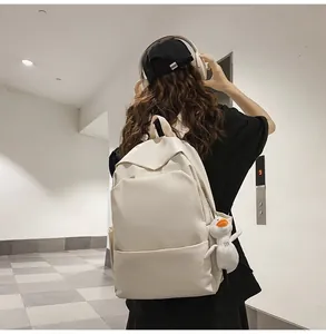 Minimalist beige waterproof backpack with a cute small duck plush charm on a side strap