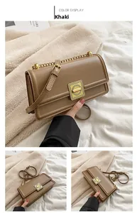 Detail view of khaki leather crossbody bag with metal chain strap and square buckle