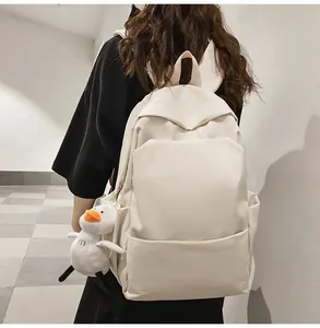 Back view of a minimalist cream waterproof backpack with a cute duck plush accessory