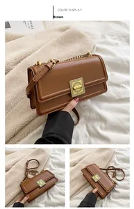Detail of brown faux leather crossbody bag featuring a gold square twist lock and chain strap