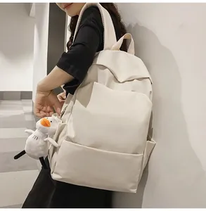Minimalist cream waterproof backpack with dual front pockets and cute duck plush charm