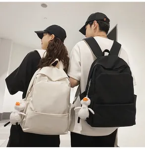 Minimalist waterproof backpacks in black and beige with cute duck plush charms for students