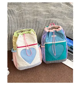 Dettaglio di zaini da trekking color-block con tasche a rete a cuore e chiusura a coulisse