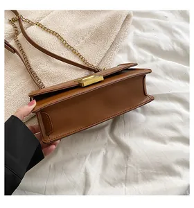Detail showing the brown faux leather bag with two compartments and gold chain strap