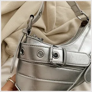 Detail shot of metallic silver shoulder bag showing the textured faux leather and metal eyelets