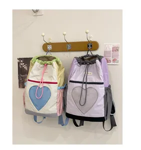 Dettaglio delle tasche in rete a forma di cuore e chiusura a coulisse degli zaini