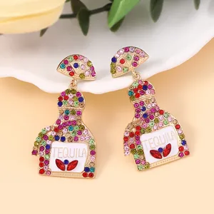 Detailed view of rhinestone tequila bottle earrings in gold-tone alloy with colorful gems