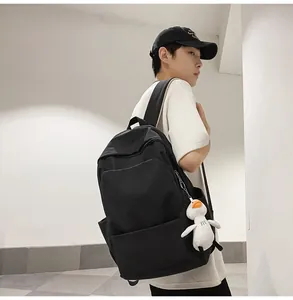 Black waterproof nylon backpack featuring large pockets and a cute duck plush accessory
