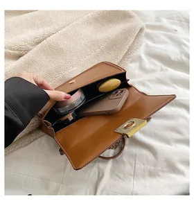 Internal view showing large capacity for phone and cosmetics in brown PU bag