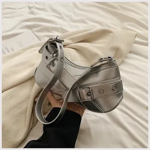 Detail of silver metallic crescent bag with punk buckle straps and eyelets