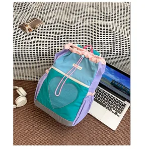 Dettaglio dello zaino outdoor multicolore con tasca a rete a cuore e coulisse rosa