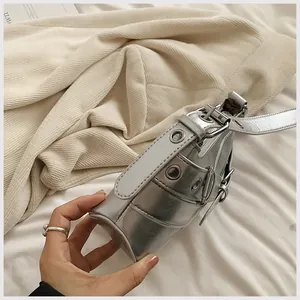 Detailed macro of silver Y2K shoulder bag featuring metallic eyelets and buckle accents