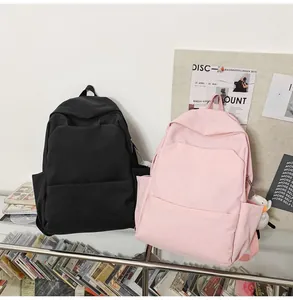 Detail of waterproof nylon backpacks in pink and black with a cute plush duck charm