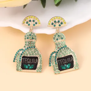 Detail view of Tequila bottle earrings with sparkling green rhinestones and lemon slice charms