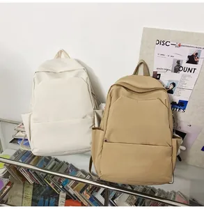 Detail view of cream and khaki waterproof minimalist backpacks with side pockets and plush charm