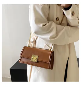 Detail of dark brown leather texture and golden square metal buckle on women's handbag