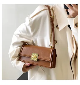 Macro shot of brown PU leather shoulder bag featuring vintage square gold metal buckle