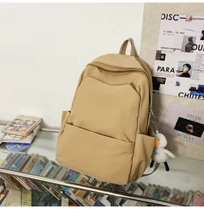 Close-up of waterproof khaki backpack with a cute white duck plush charm accessory