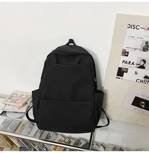 Detail view of the black waterproof backpack featuring the front pocket and side compartment