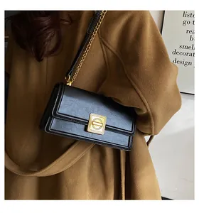 Close-up of black retro PU leather handbag featuring a golden metallic geometric lock and chain strap